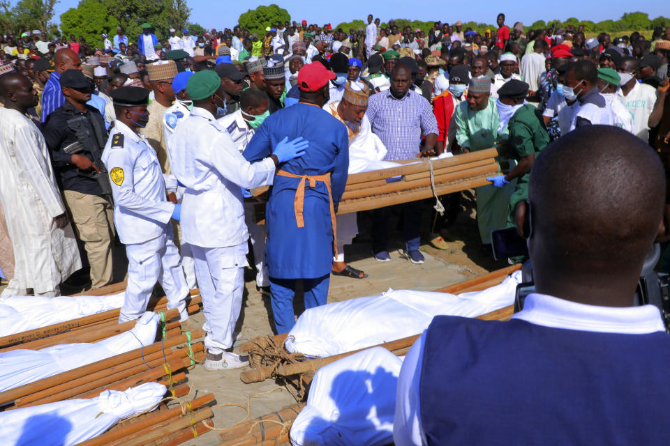 People attend a funeral for those killed by suspected Boko Haram militants in Zaabarmar, Nigeria, Sunday, Nov. 29, 2020. Nigerian officials say suspected members of the Islamic militant group Boko Haram have killed at least 40 rice farmers and fishermen while they were harvesting crops in northern Borno State. The attack was staged Saturday in a rice field in Garin Kwashebe, a Borno community known for rice farming. (AP Photo/Jossy Ola)