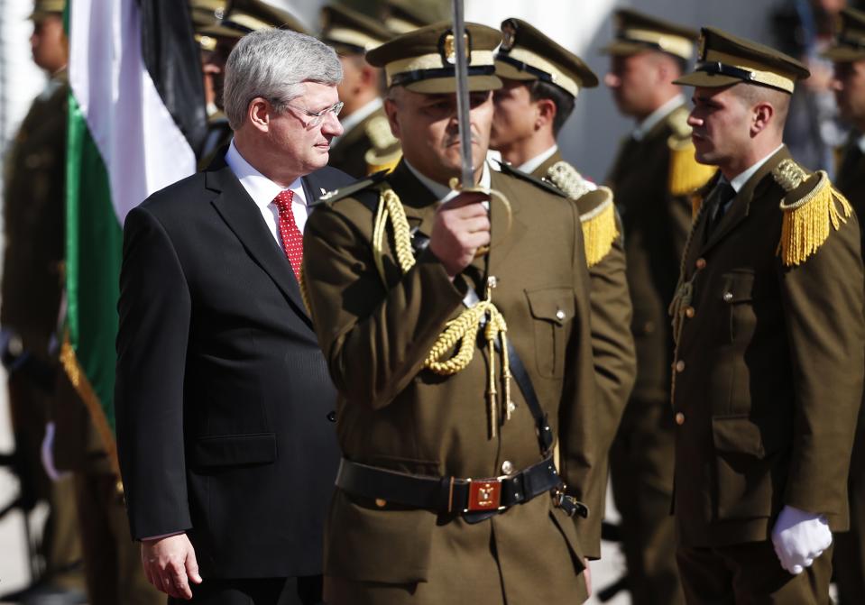 Canada's Prime Minister Harper reviews an honour guard ceremony before his meeting with Palestinian President Abbas in Ramallah