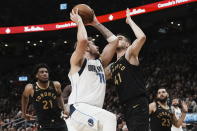 Dallas Mavericks' Luka Doncic (77) looks to shoot against Toronto Raptors' Juancho Hernangomez (41) as Raptors' Thaddeus Young, left, and Fred VanVleet look on during first-half NBA basketball game action in Toronto, Saturday, Nov. 26, 2022. (Chris Young/The Canadian Press via AP)