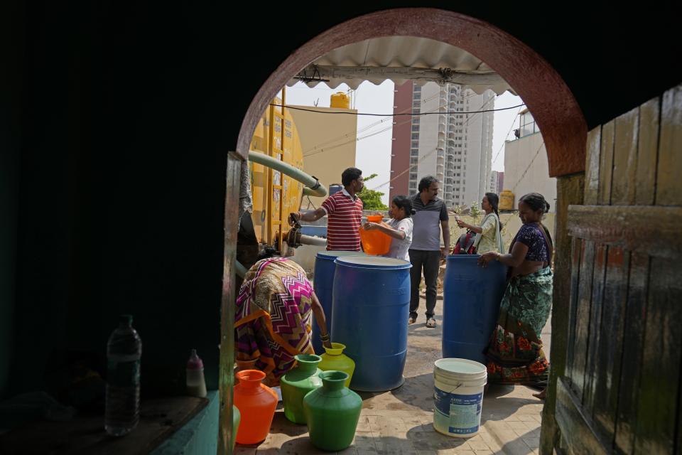 Residents of Ambedkar Nagar, a low-income settlement in the shadows of global software companies in Whitefield neighborhood, collect potable water from a private tanker in Bengaluru, India, Monday, March 11, 2024. (AP Photo/Aijaz Rahi)
