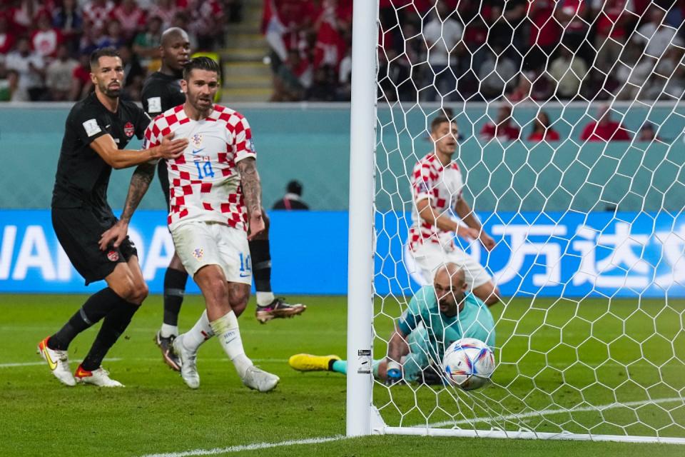 Canada&#39;s goalkeeper Milan Borjan, on the ground, eyes the ball after Croatia&#39;s Andrej Kramaric, background right, scored his side&#39;s first goal during the World Cup group F football match between Croatia and Canada, at the Khalifa International Stadium in Doha, Qatar, Sunday, Nov. 27, 2022. (AP Photo/Martin Meissner)