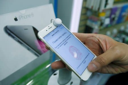 A man holds an iPhone 6 in a mobile phone shop in Moscow, Russia, September 26, 2014. REUTERS/Maxim Shemetov/File Photo