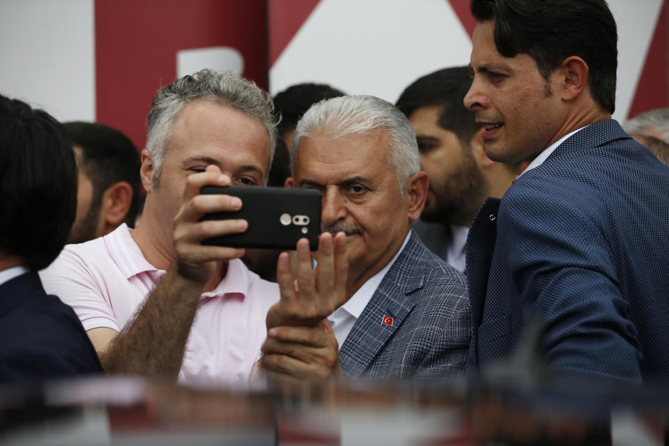 In this Friday, June 21, 2019 file photo, Binali Yildirim, mayoral candidate for Istanbul from Turkey's ruling Justice and Development Party, AKP, takes photos with supporters following a rally in Istanbul, ahead of the June 23 re-run of mayoral elections. Voters in Istanbul return to the polls on Sunday for a rerun of the election for the mayor of the city. (AP Photo/Lefteris Pitarakis)