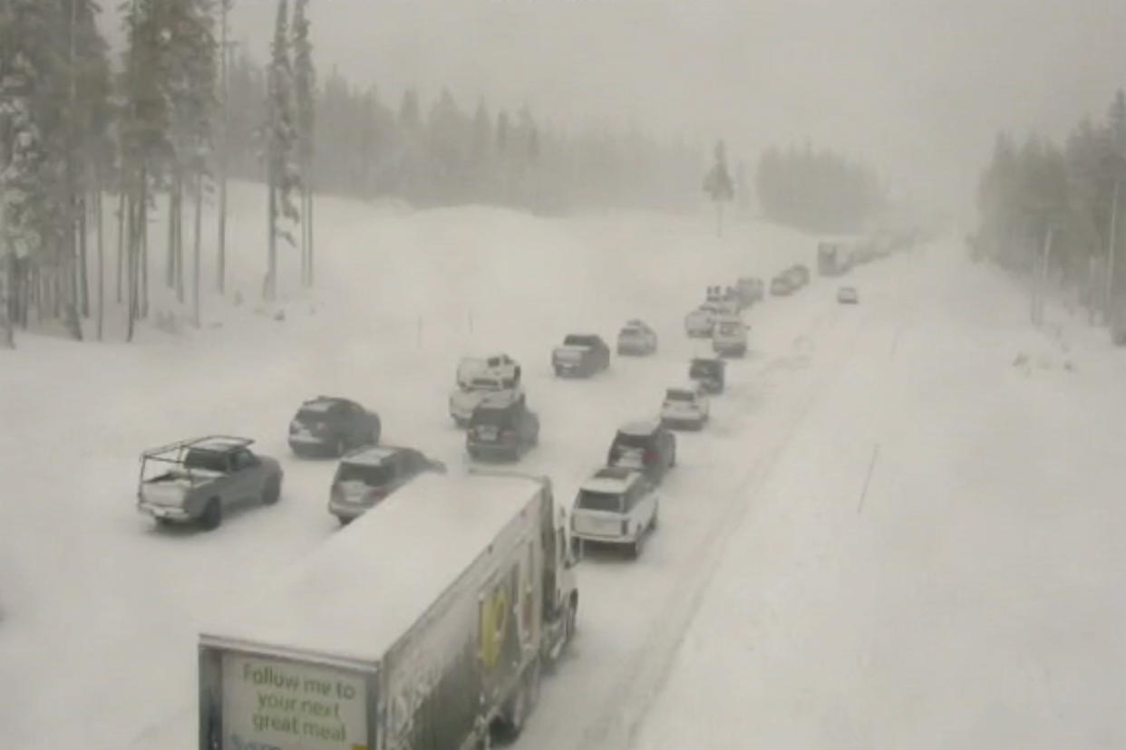 In this image taken from video from a Caltrans remote video traffic camera, traffic is stopped along a snow covered Interstate 80 at Donner Summit, Calif., on Thursday, Dec. 23, 2021. (Caltrans via AP)