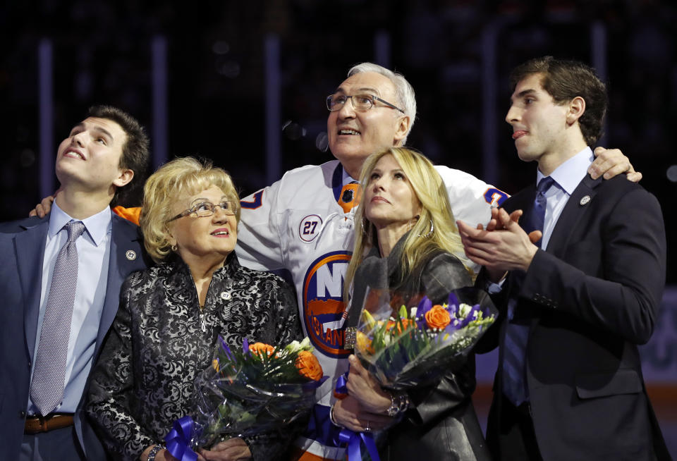 Former New York Islander John Tonelli, center, stands with his mother, Joy, second from left; wife, Lauren; and sons Jordan and Zach as he watches while his jersey No. 27 is raised to the rafters during his jersey retirement ceremony Friday, Feb. 21, 2020, in Uniondale, N.Y. (AP Photo/Kathy Willens)