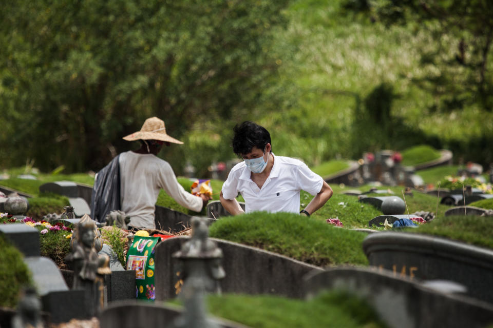 A man wearing a protective mask visits a tomb at the Chua Chu Kang cemetery during the Qing Ming Festival amid the coronavirus disease outbreak in Singapore on 5 April, 2020. (PHOTO: LightRocket via Getty Images)
