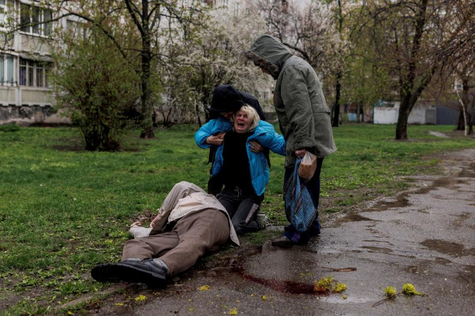 Yana Bachek is consoled by her partner Yevgeniy Vlasenko and her mother Lyubov Gubareva, as she mourns over the body of her father Victor Gubarev, 79, killed by shelling during Russia's invasion of Ukraine (Reuters)