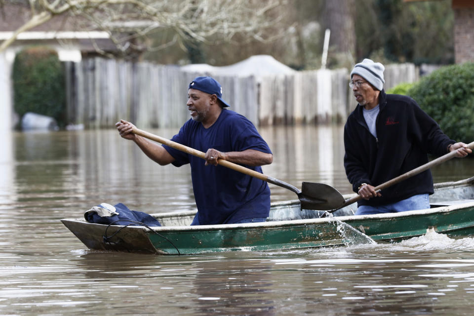 Jackson, Miss., homeowners use shovels to work their way through Pearl River floodwater in this Jackson, Miss., neighborhood Sunday, Feb. 16, 2020. Residents of Jackson braced Sunday for the possibility of catastrophic flooding in and around the Mississippi capital as the Pearl River rose precipitously after days of torrential rain. (AP Photo/Rogelio V. Solis)