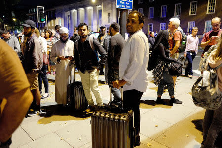 Commuters are seen outside Euston Station after police evacuated the area following a security alert in London, Britain, August 29, 2017. REUTERS/Tolga Akmen