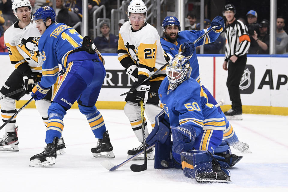 St. Louis Blues goaltender Jordan Binnington (50) and St. Louis Blues defenseman Robert Bortuzzo (41) defend the net from Pittsburgh Penguins left wing Brock McGinn (23) during the first period of an NHL hockey game, Saturday, Feb. 25, 2023, in St. Louis. (AP Photo/Jeff Le)