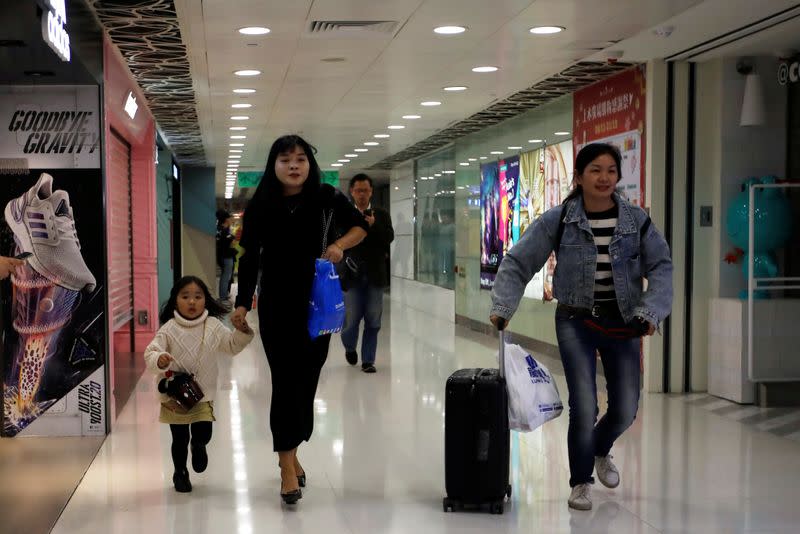 Shoppers run towards the exit as anti-government demonstrators protest inside the Sheung Shui shopping mall in Hong Kong