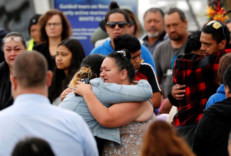Relatives hug as they wait for rescue mission, following the White Island volcano eruption in Whakatane