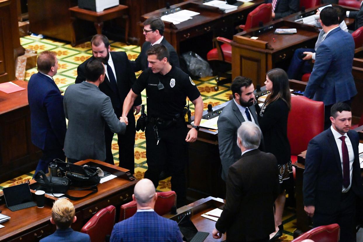 Officer Rex Engelbert, center, shakes hands with lawmakers as he and other emergency workers who responded to the Covenant School shooting are honored in the House of Representatives at the State Capitol in Nashville, Tenn., on Thursday, April 13, 2023.