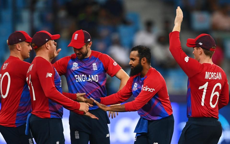 Adil Rashid of England celebrates the wicket of Obed McCoy of West Indies with team mate Jonny Bairstow during the ICC Men's T20 World Cup match between England and Windies at Dubai International Stadium on October 23, 2021 in Dubai, United Arab Emirates.  - GETTY IMAGES