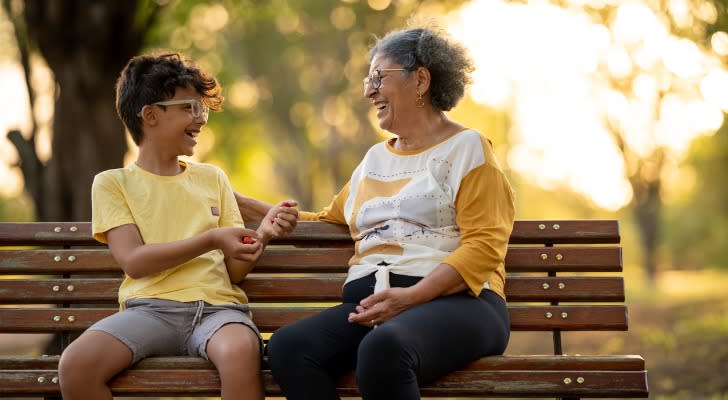 A retiree enjoys the benefits of her retirement plan with her grandchild.