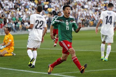 Mexico's Oribe Peralta celebrates after scoring a goal as New Zealand's Glen Moss, Andrew Durante and Storm Roux (L-R) react during their 2014 World Cup qualifying playoff second leg soccer match at Westpac Stadium in Wellington November 20, 2013. REUTERS/Anthony Phelps