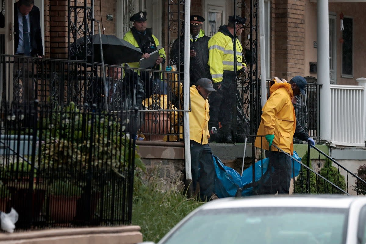 A body is removed as police investigate the scene of a quadruple shooting on the 5900 block of Palmetto Street in Philadelphia’s Crescentville section on Friday (AP)