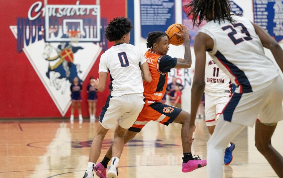 Cosumnes Oaks’ Jay Washington, middle, moves the ball during the Sac-Joaquin Section Division I playoff game Modesto Christian at Modesto Christian High School in Salida, Calif., Wednesday, Feb. 14, 2024.