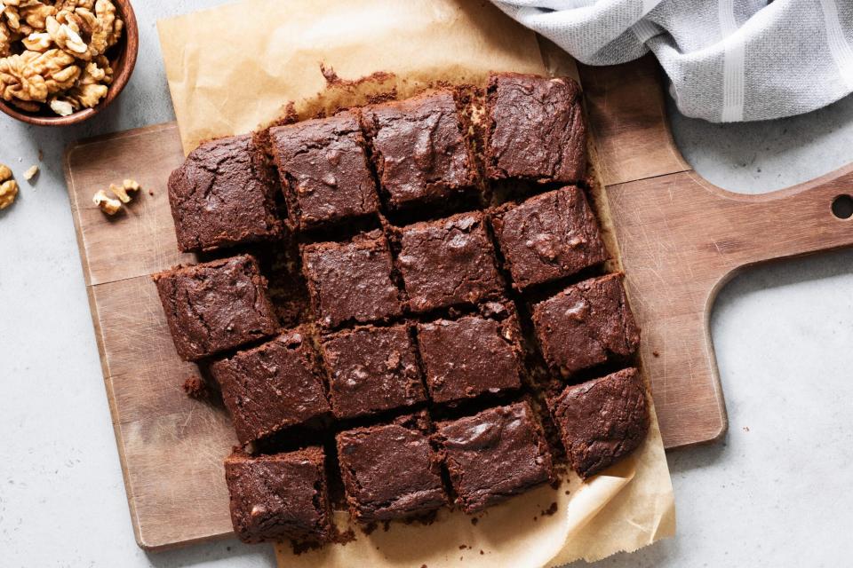 Chocolate brownie squares with walnuts on cutting board