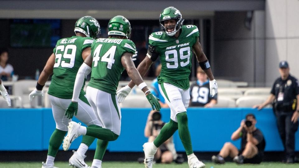 Aug 12, 2023; Charlotte, North Carolina, USA; New York Jets defensive end Will McDonald IV (99) reacts with defensive tackle Bruce Hector (69) and linebacker Jamien Sherwood (44) after making a sack in the second quarter at Bank of America Stadium.