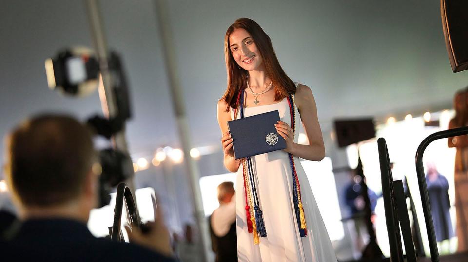 Nicollette Heath holds her new diploma during graduation at Notre Dame Academy in Hingham on Friday, May 19, 2023.