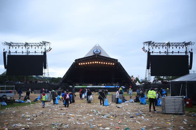 Festival-goers help in cleaning up the venue at the end of Glastonbury, on June 27, 2022. (Photo: ANDY BUCHANAN via Getty Images)