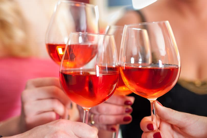 Raising glasses of  rose wine