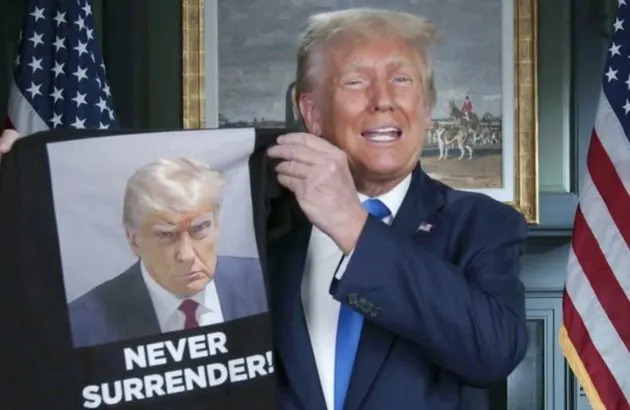 Donald Trump holds up a T-shirt for sale in a video on his Truth Social website.