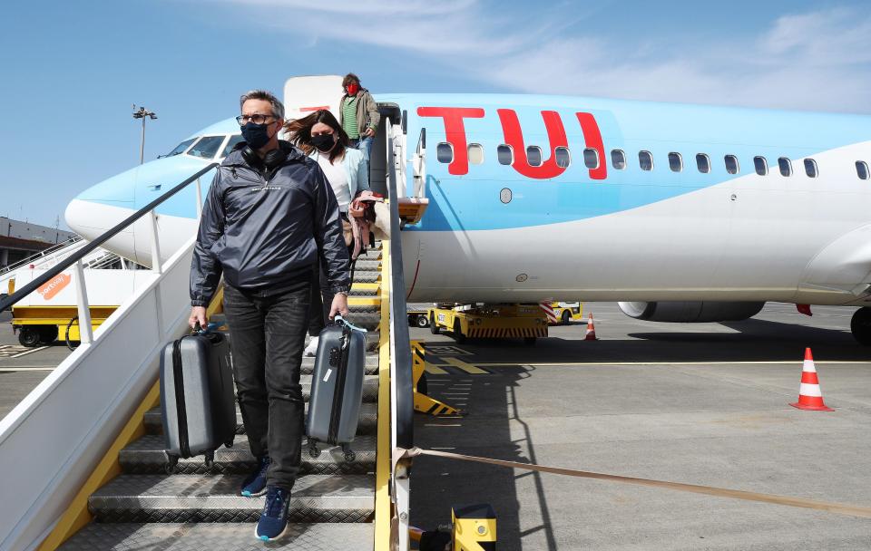 Passengers disembark from an early morning flight to Madeira (PA)