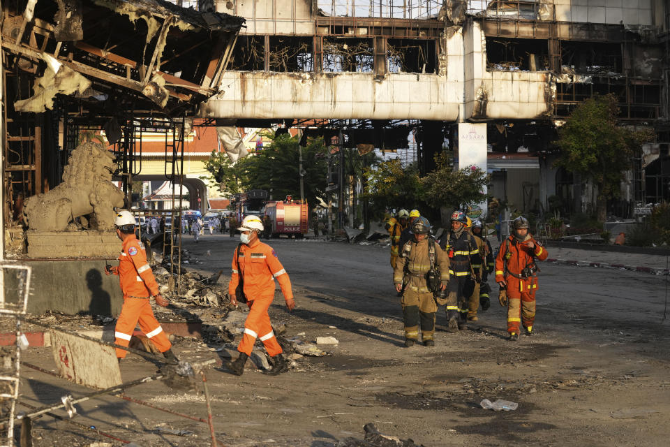 Cambodian and Thai rescue experts walk through a ruined building for a searching operation at the scene of a massive fire at a Cambodian hotel casino in Poipet, west of Phnom Penh, Cambodia, Friday, Dec. 30, 2022. The fire at the Grand Diamond City casino and hotel Thursday injured over 60 people and killed more than a dozen, a number that officials warned would rise after the search for bodies resumes Friday. (AP Photo/Heng Sinith)