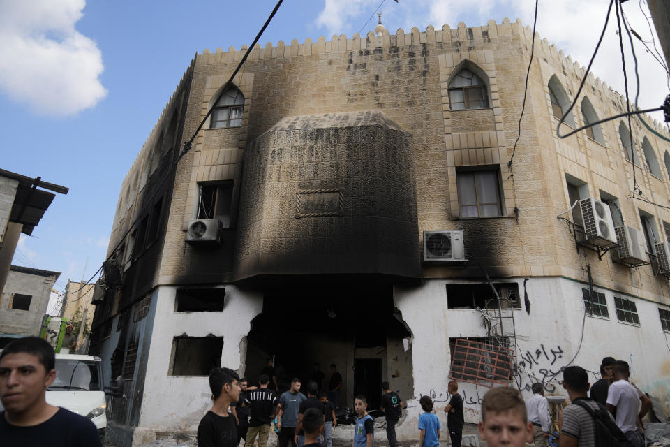 Palestinians stand outside a heavily damaged mosque following an Israeli military operation in the West Bank refugee camp of Al-Faraa, Thursday, Aug. 29, 2024. (AP Photo/Nasser Nasser)