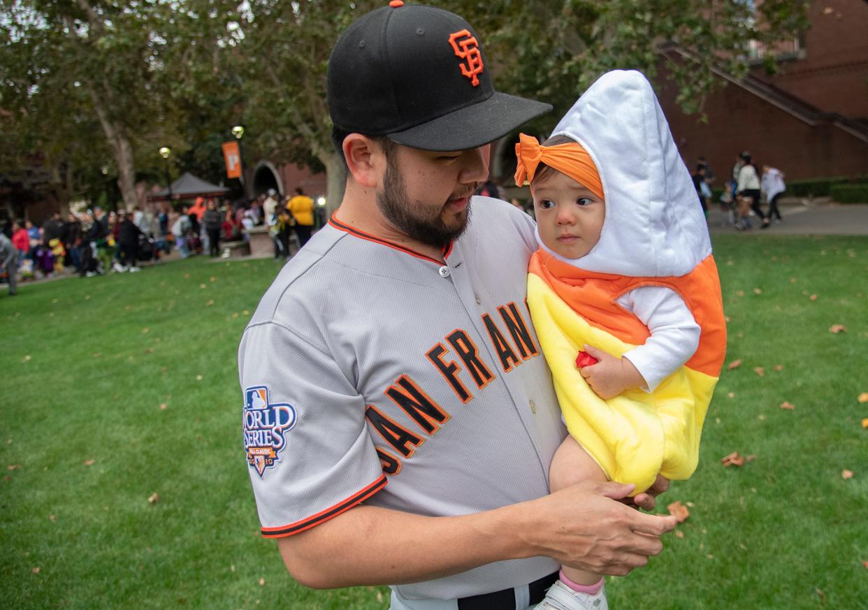 Robert Endow of Stockton carries his 1-year-old daughter Violet Endow dressed as candy corn at the annual Pacific Trick or Treat event on the University of the Pacific's DeRosa University Center Lawn in Stockton on Oct. 25, 2023. Various college groups and organization gave out candy and set up games for thousands of children and their parents to play.