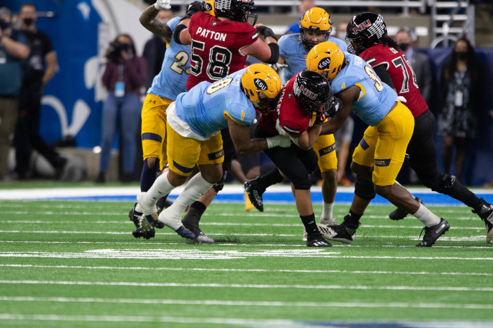 Kent State defensive lineman Zayin West (left) makes a tackle during the 2022 MAC Championship Game against Northern Illinois in Detroit.