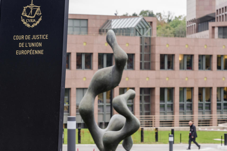 FILE - A man walks by the European Court of Justice in Luxembourg, Oct. 5, 2015. A group of top soccer clubs face Champions League organizer UEFA in court on Monday, July 11, 2022, for a legal match that risks the biggest upheaval in European soccer for more than 25 years. The Super League project failed at launch 15 months ago but the company formed by the 12 rebel clubs — now led by Real Madrid, Barcelona and Juventus — has brought a case to the Court of Justice of the European Union in Luxembourg. (AP Photo/Geert Vanden Wijngaert, File)