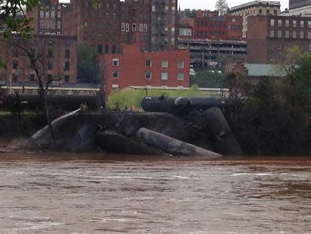 Emergency personnel attend to a CSX Corp train carrying crude oil that derailed and burst into flames in downtown Lynchburg, Virginia, April 30, 2014. REUTERS/WSET/Handout via Reuters