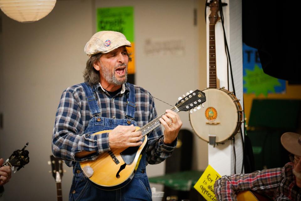 David Baker, co-owner of The Shoe Tree Listening Room, belts out a line during a Bluegrass Jam on Thursday, Feb. 8, 2024. During the jam, participants passed around a microphone, singing bluegrass tunes, while others "picked" with them.