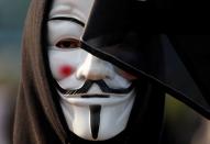 An anti-government demonstrator wearing a Guy Fawkes mask takes part in a protest at Edinburgh Place in Hong Kong