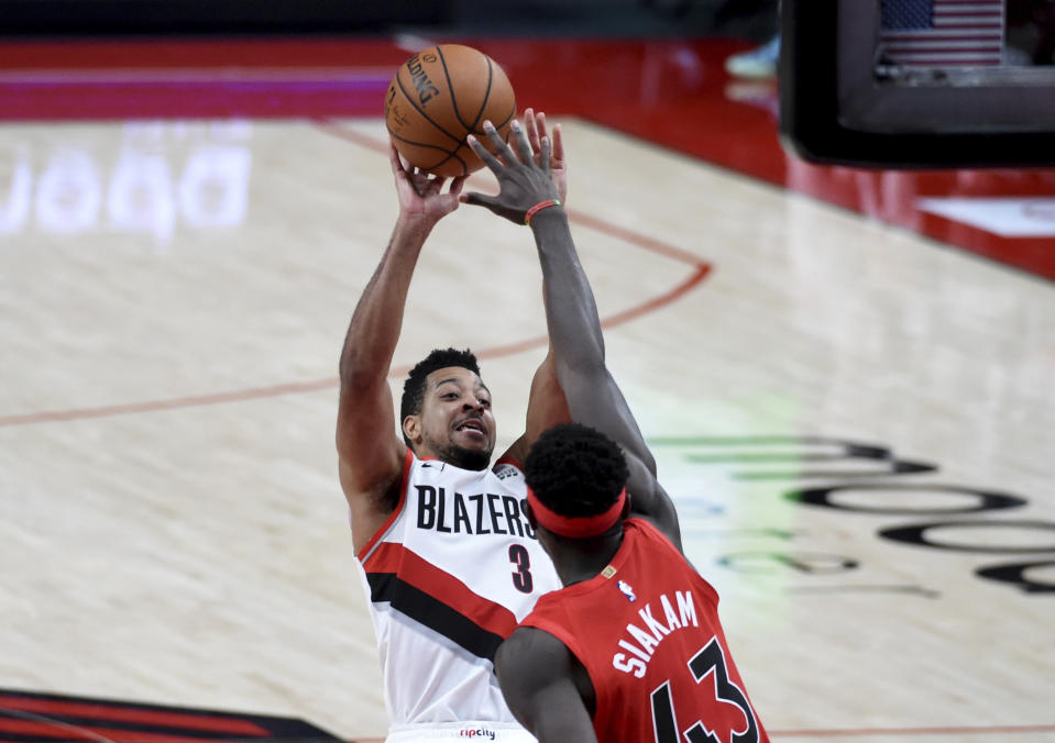 Portland Trail Blazers guard CJ McCollum, left, shoots over Toronto Raptors forward Pascal Siakam late in the second half of an NBA basketball game in Portland, Ore., Monday, Jan. 11, 2021. The Blazers won 112-111. (AP Photo/Steve Dykes)