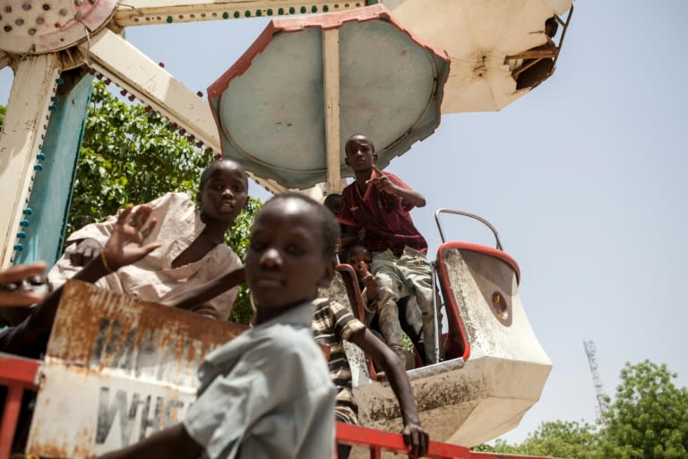 Children orphaned by Boko Haram Islamists play on a spinning wheel at an abandoned amusement park in Maiduguri, Nigeria