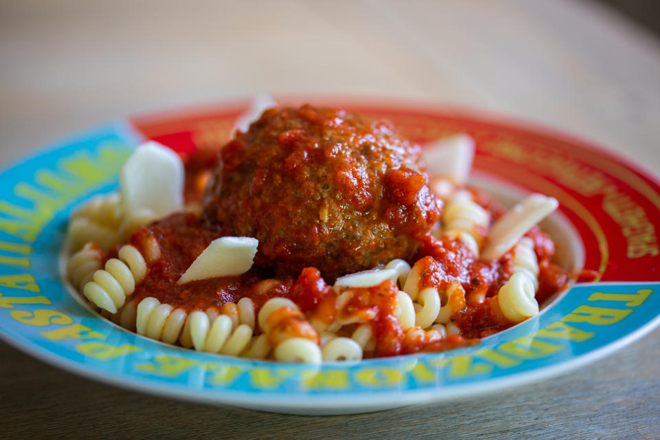 Plate with pasta, meatballs, and sauce, on a child-friendly designed plate