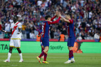 Barcelona's Pedri, center, is congratulated after scoring his side's 3rd goal during a Spanish La Liga soccer match between Barcelona and Rayo Vallecano at the Olimpic Lluis Companys stadium in Barcelona, Spain, Sunday, May 19, 2024. (AP Photo/Joan Monfort)