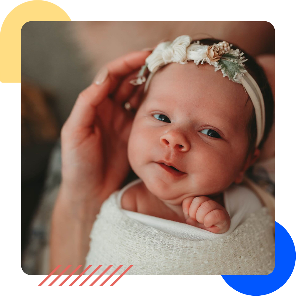 A baby with a ribbon around their head