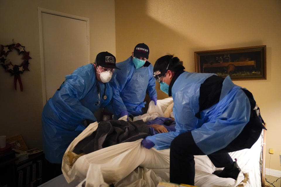 Emergency medical workers Jacob Magoon, from left, Joshua Hammond and Thomas Hoang lift a patient onto a gurney in Placentia, Calif., on Jan. 9, 2021. California's COVID-19 emergency declaration ends on Tuesday, Feb. 28, 2023. Gov. Gavin Newsom first issued the emergency declaration on March 4, 2020. The emergency ends just as California officially passed 100,000 COVID-related deaths during the pandemic. (AP Photo/Jae C. Hong, File)