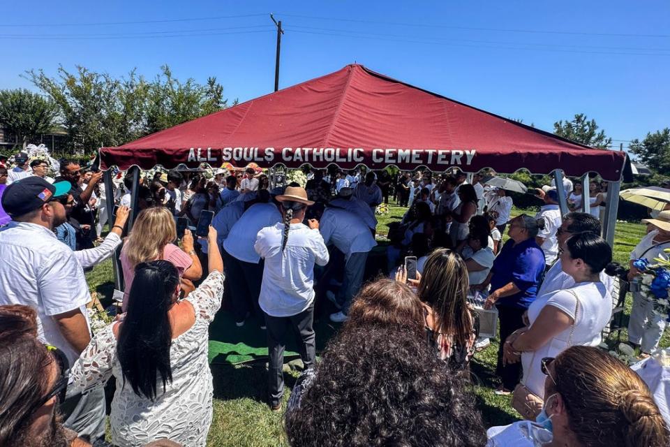 The burial service at All Souls Cemetery in Long Beach. At the end, the family releases doves into the sky.