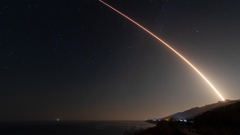 A SpaceX rocket streaks into space from California's Vandenberg Space Force Station at night.