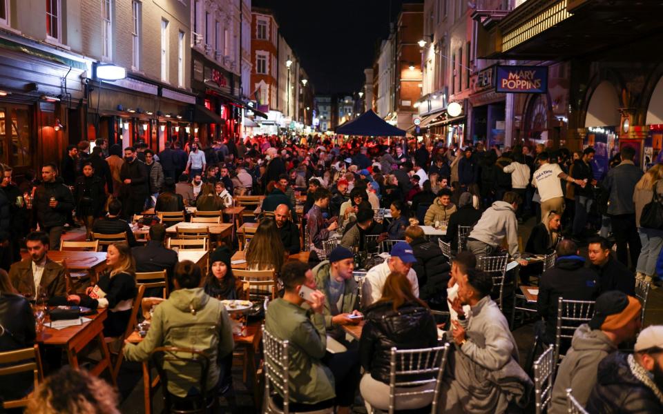 People dine and party along a street in Soho as lockdown rules are eased - REUTERS