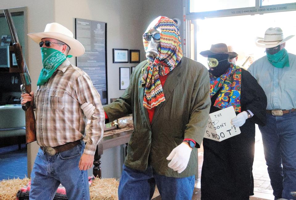 The Lone Stranger and Sidekick are escorted into Plumas Bank on Hilltop Drive where they staged the annual mock bank robbery on Tuesday, May 17, 2022, as part of Redding Rodeo Week. The Asphalt Cowboys give daily clues to identify the pretend robbers and locate the loot for cash prizes.