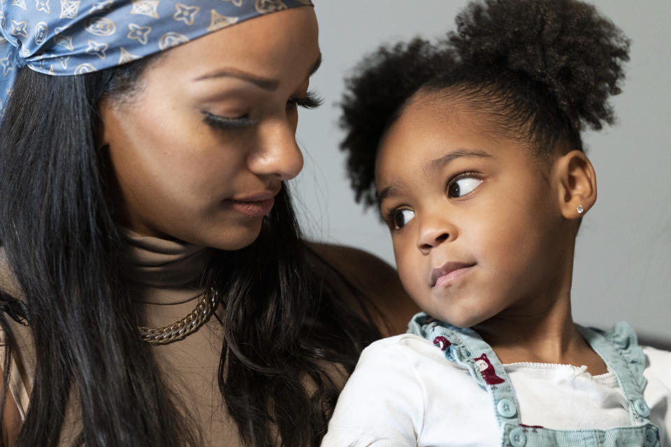 Katherine Guzmán conversa con Jazzmyn, la medio hermana que adoptó luego de la muerte de su madre a raíz del coronavirus. Foto del 17 de septiembre tomada en la casa de Guzmán en Newark, Nueva Jersey. (AP Photo/Mary Altaffer)