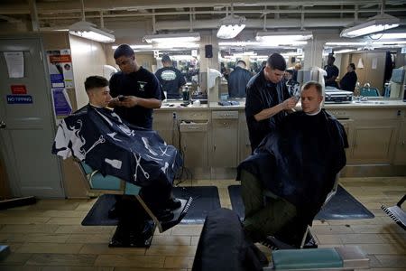 US Navy sailors gets a hair cut at the barber shop on board of the USS Harry S. Truman aircraft carrier in the eastern Mediterranean Sea, June 14, 2016. REUTERS/Baz Ratner