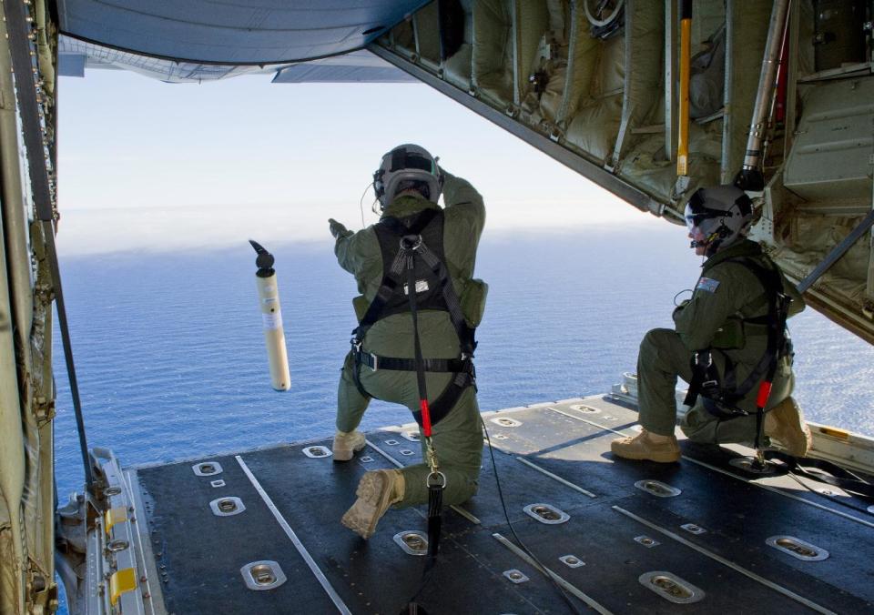 FILE - In this March 20, 2014 file photo provided by the Australia Defence Department, Royal Australian Air Force Loadmasters Sgt. Adam Roberts, left, and Flight Sgt. John Mancey, launch a Self Locating Data Marker Buoy from a C-130J Hercules aircraft in the southern Indian Ocean as part of the Australian Defence Force's assistance to the search for Malaysia Airlines flight MH370. The disappearance of the airplane has presented two tales of modern technology. The public has been surprised to learn of the limitations of tracking and communications devices, which contributed to the plane vanishing for more than two weeks. But the advanced capabilities of some technologies, particularly satellites, have provided hope that the mystery won't go unsolved. (AP Photo/Australian Defence Department, Justin Brown, File)